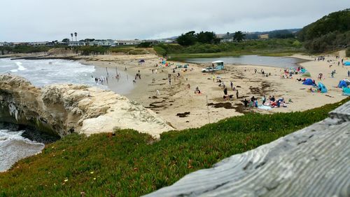 High angle view of people at beach against cloudy sky