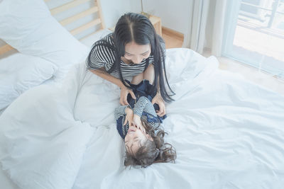 High angle view of woman with daughter on bed at home
