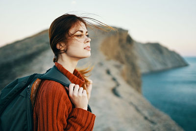 Mid adult woman looking away against sea