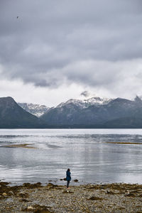 Scenic view of a young girl on a beach in norway during a cloudy day