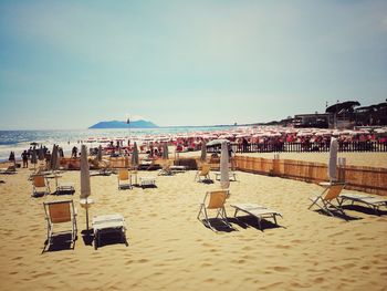 Chairs on beach against sky