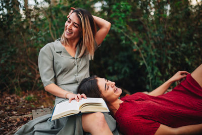 Smiling friends relaxing in forest