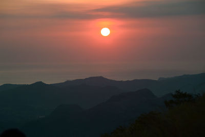 Scenic view of silhouette mountains against sky during sunset