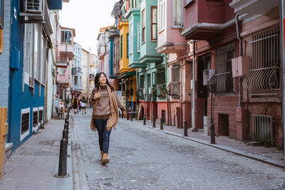Rear view of woman walking on street in city