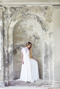 Full length of woman standing against wall