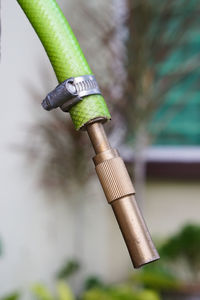 Close-up of metallic pipe in garden hose at backyard