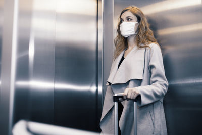 Woman looking away while standing in corridor