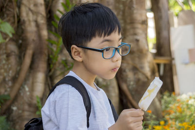 Close-up of thoughtful boy holding flavored ice