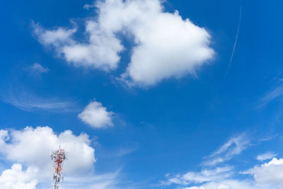 Low angle view of woman standing against blue sky