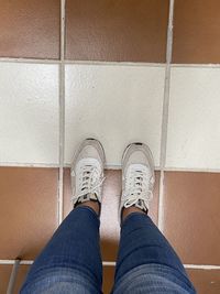 Low section of man standing on tiled floor