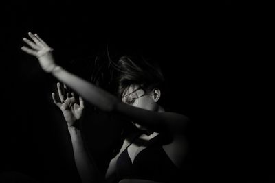 Girl looking away against black background