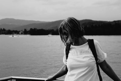 Woman standing by sea against sky