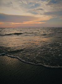 A moving small wave at the beach during sunset