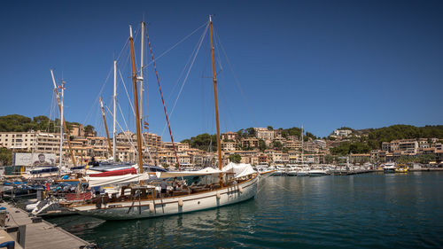 Sailboats moored at harbor against clear sky, puert de soller, mallorca 