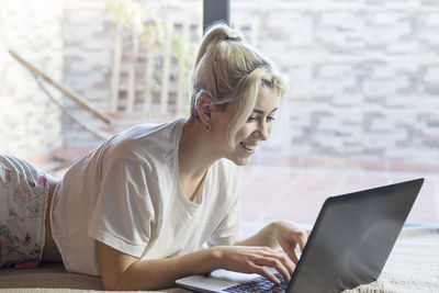 Smiling woman using laptop at office