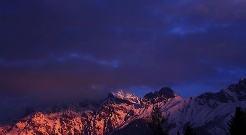 Scenic view of snow covered mountains against sky at night