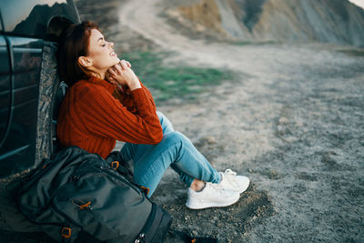 Woman looking away while sitting outdoors