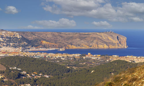 Scenic view of sea and cityscape against sky