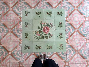 Low section of person standing on tiled floor