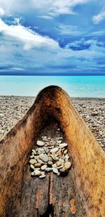 Stone wall on beach against sky