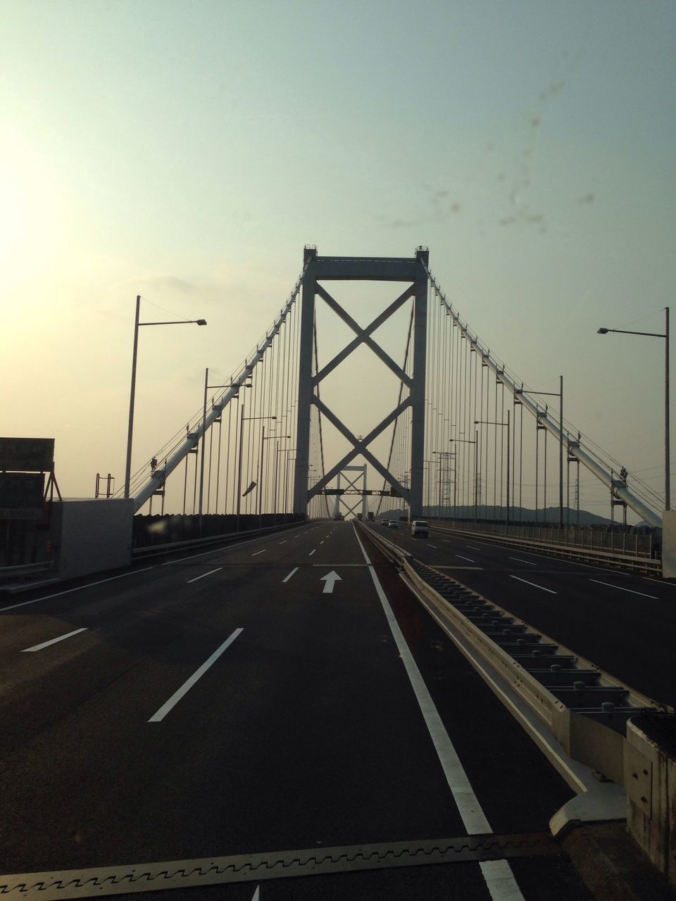 transportation, road marking, road, the way forward, connection, clear sky, built structure, bridge - man made structure, sky, architecture, diminishing perspective, street light, car, copy space, vanishing point, outdoors, sunset, engineering, no people, street