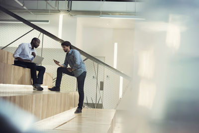 Businessman using laptop and discussing with colleague