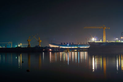 Illuminated commercial dock against clear sky at night