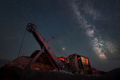 Low angle view of crane against sky at night