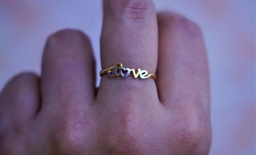 Close-up of person hand with text on metal