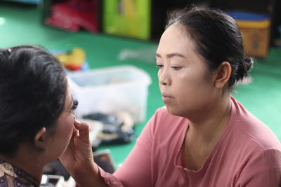 Woman applying make-up on friend