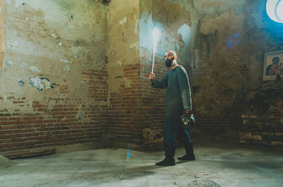 Brave viking warrior with beard in chain mail and flaming sword stands in ancient mysterious castle.