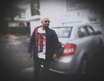 Portrait of young man standing in car