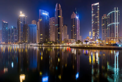 Reflection of illuminated buildings in city at night