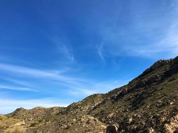 Low angle view of mountain against blue sky