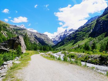 Road amidst plants and mountains against sky