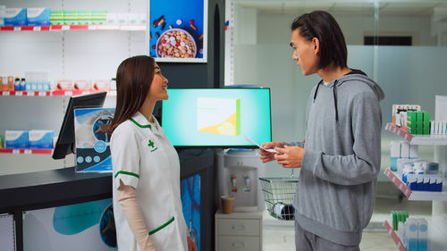 Rear view of woman using digital tablet in office