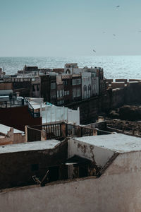 High angle view of buildings by sea against clear sky