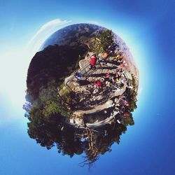 Digital composite image of people by tree against blue sky