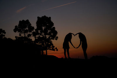 Silhouette man standing by tree against sky during sunset