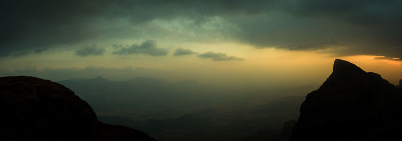 Scenic view of mountains against cloudy sky