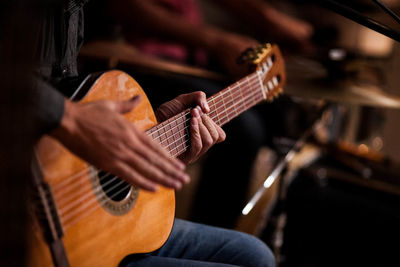 Midsection of man playing guitar