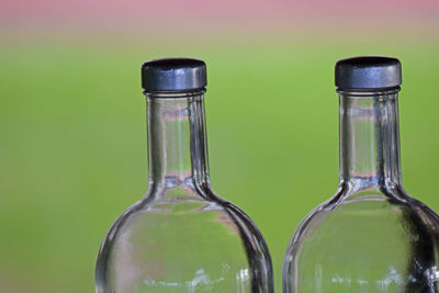Close-up of glass bottle against green background