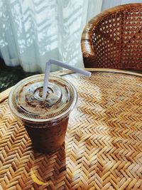 Iced coffee cup on weave furniture with nature light