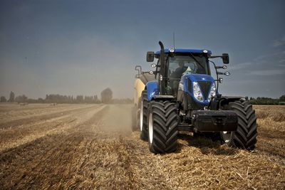 Tractor on agricultural field against sky