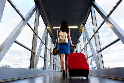 Full length of woman with umbrella on airport