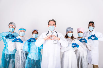 Doctors wearing mask standing against white background