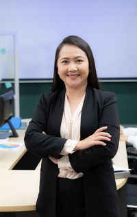 Portrait of businesswoman standing in car