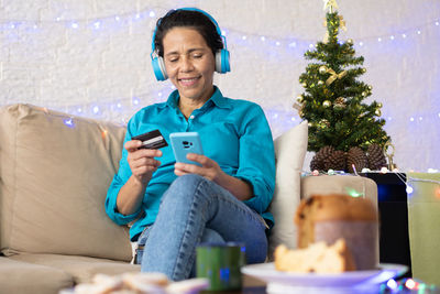 Young man using mobile phone while sitting on sofa