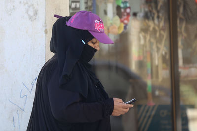 Side view of woman using mobile phone