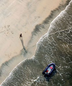 High angle view of man walking on shore at beach
